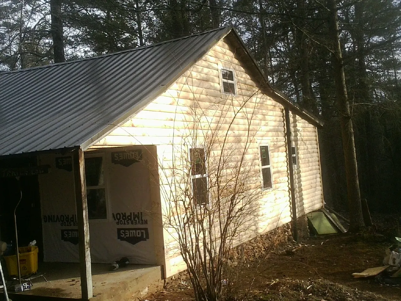 Log siding gable end under a dark metal roof edge in Fort Klamath
