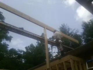 Carpenter setting a ridge beam over a new addition frame — Ice Dam Removal by Roofing Brothers in Fort Klamath