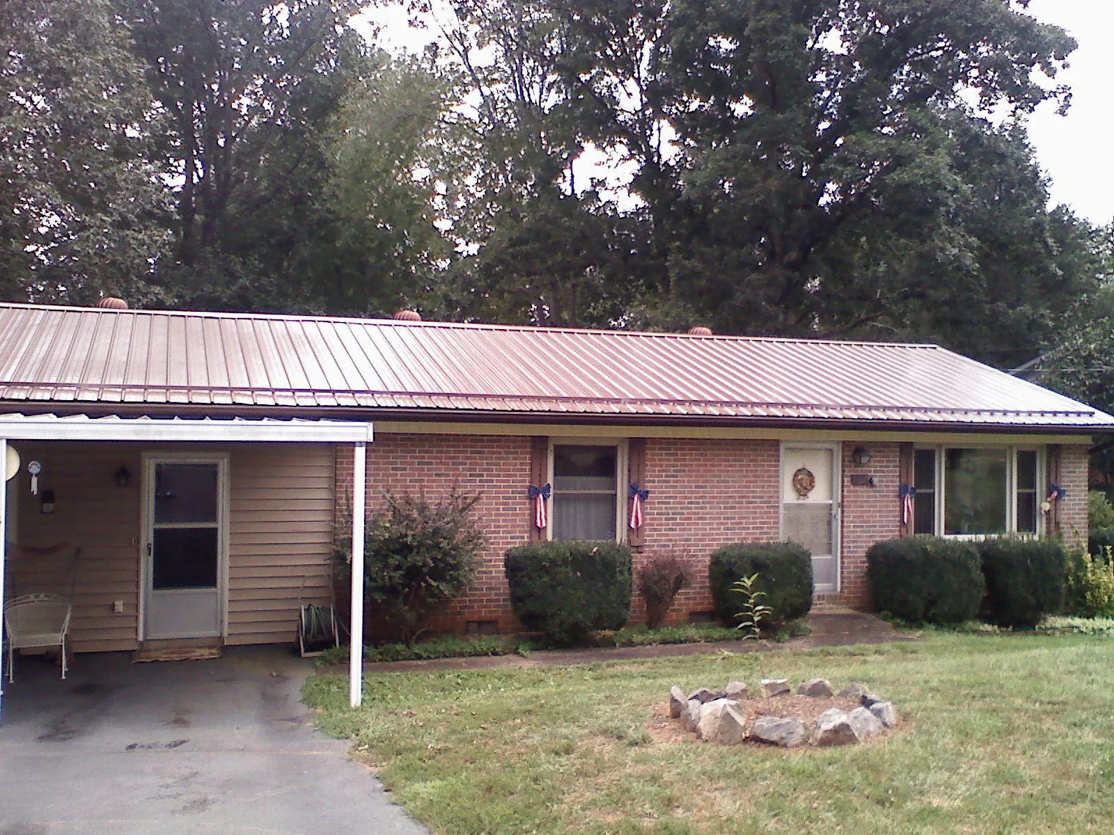 Bronze metal roof and carport on a brick ranch home — Roof Repair work by our crew in Fort Klamath